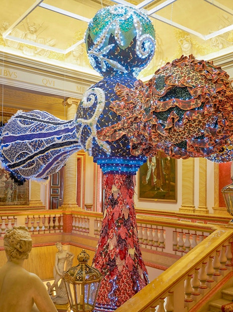 Colorful sculpture in Liria Palace interior, Madrid, with classical statues and ornate decor.