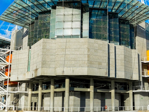 Modern architecture of Lisbon Oceanarium building, Portugal, reflecting on water.