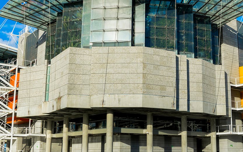 Modern architecture of Lisbon Oceanarium building, Portugal, reflecting on water.
