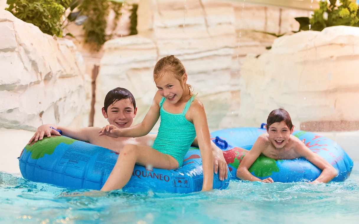 Children playing in jungle-themed water area at Bellewaerde Aquapark, Belgium.