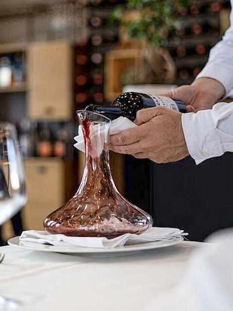 Wine being poured into a decanter during Berat City & Belshi Lake day trip.