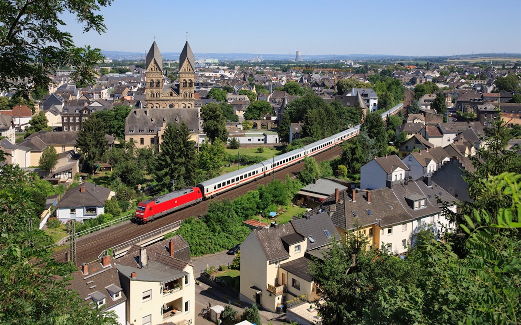 Train passing through a German town with historic church in the background.