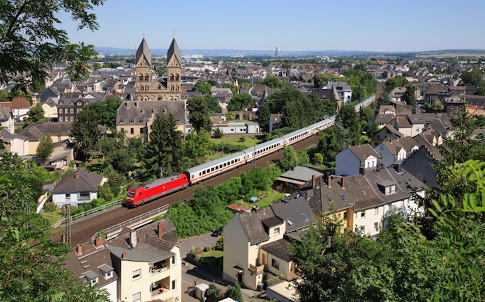 Train passing through a German town with historic church in the background.
