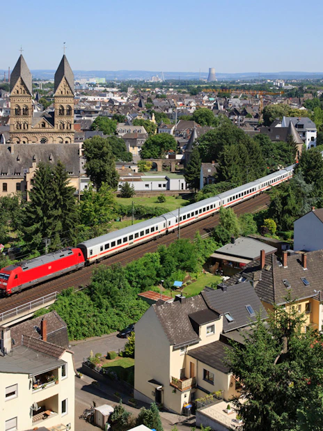 Train passing through a German town with historic church in the background.