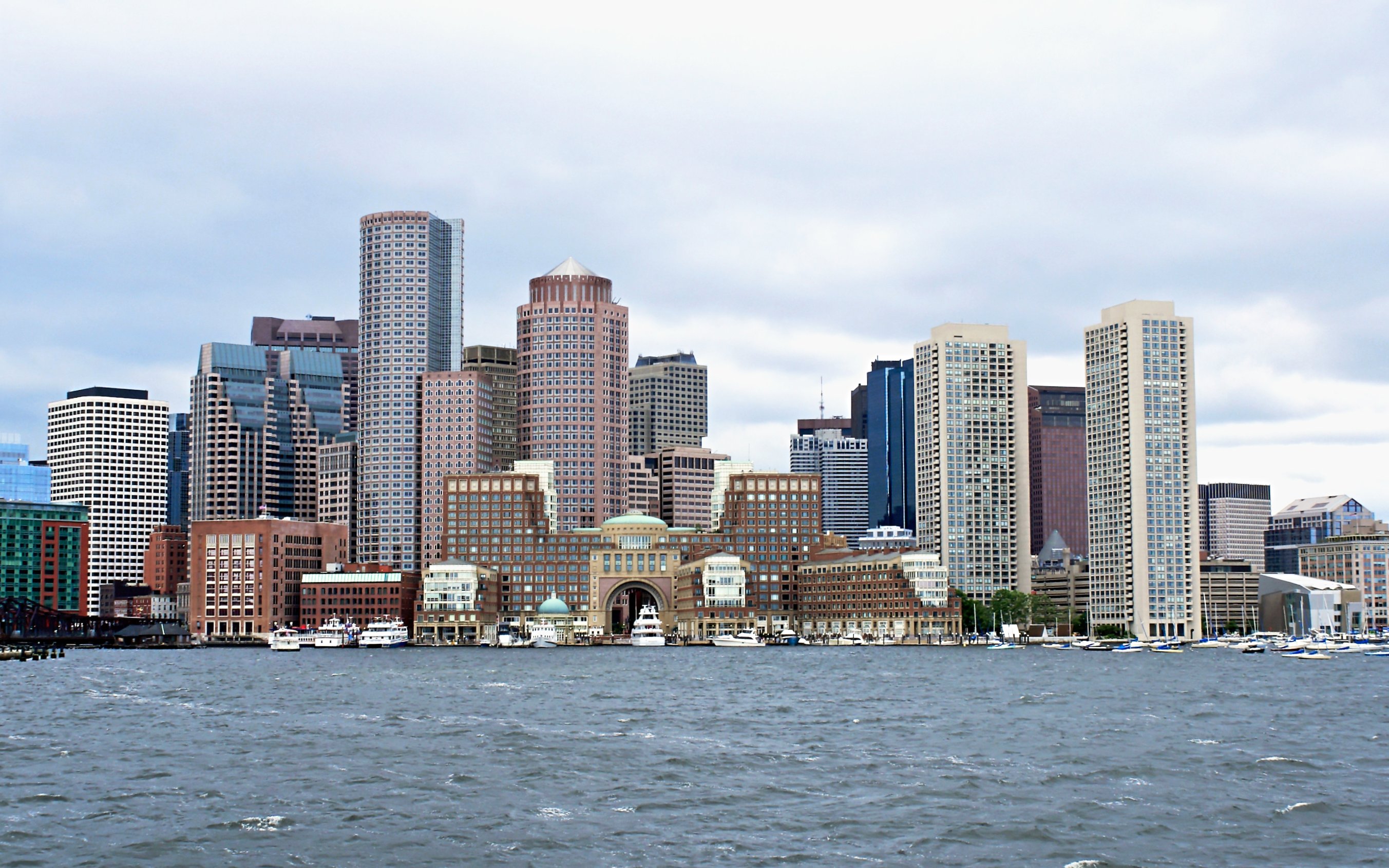 Boston skyline viewed from the harbor with prominent skyscrapers.