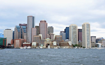 Boston skyline viewed from the harbor with prominent skyscrapers.