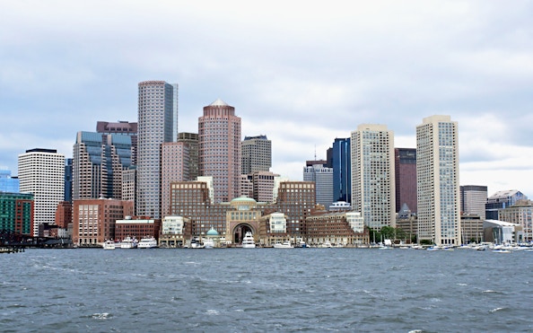 Boston skyline viewed from the harbor with prominent skyscrapers.