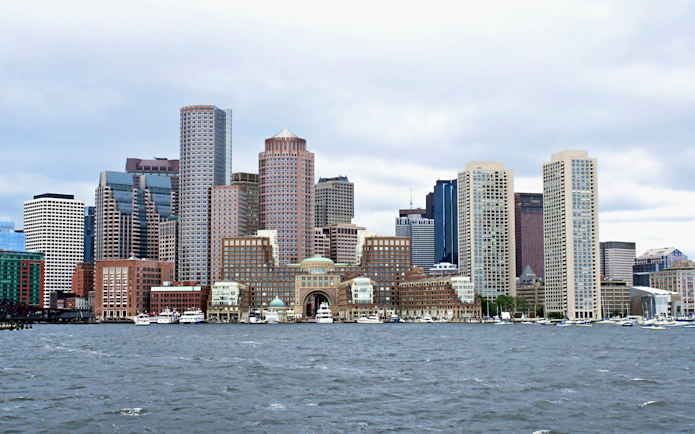 Boston skyline viewed from the harbor with prominent skyscrapers.