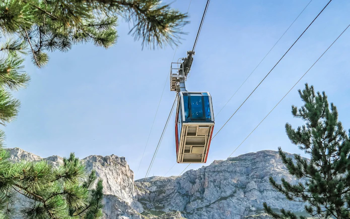 Cable car ascending in Picos de Europa, Spain, with mountain backdrop.