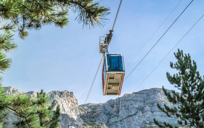 Cable car ascending in Picos de Europa, Spain, with mountain backdrop.