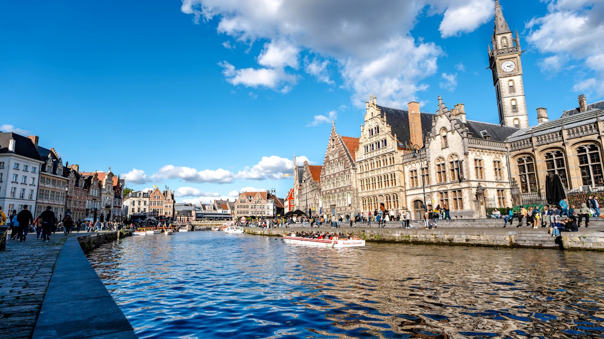 Boating on the Leie River in Ghent with historic buildings and clock tower in view.