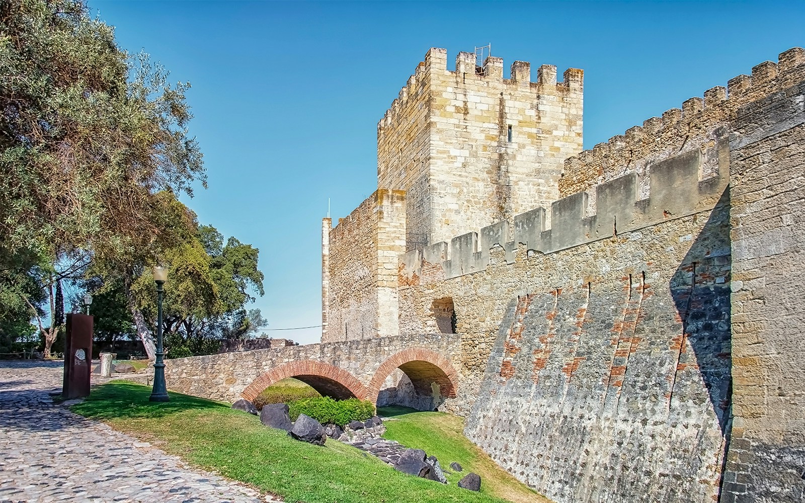 Sao Jorge Castle stone walls and arch bridge in Lisbon, Portugal.