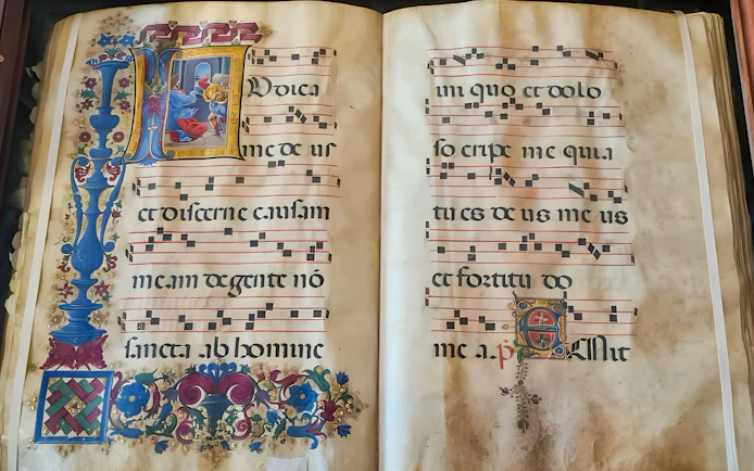 Illuminated manuscript with musical notation at Siena Duomo Complex.