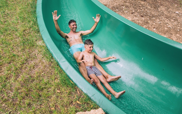 Father and son enjoying a water slide at Aqualandia Benidorm.