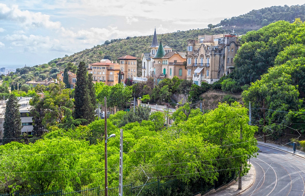Tibidabo Avenue with view of Barcelona cityscape and iconic Tibidabo Amusement Park.