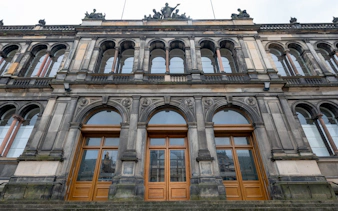 Facade of the National Museum of Scotland in Edinburgh with arched windows and ornate stonework.