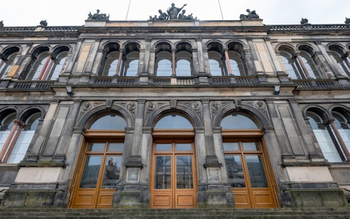 Facade of the National Museum of Scotland in Edinburgh with arched windows and ornate stonework.