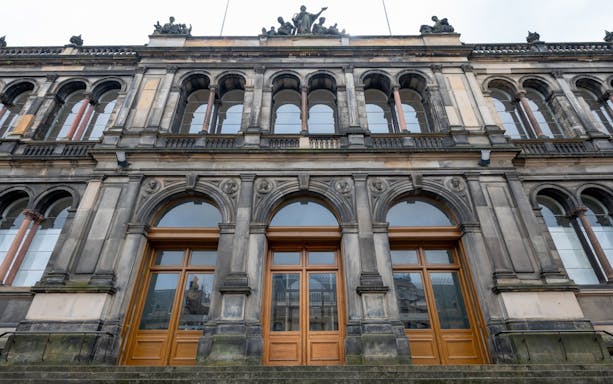 Facade of the National Museum of Scotland in Edinburgh with arched windows and ornate stonework.