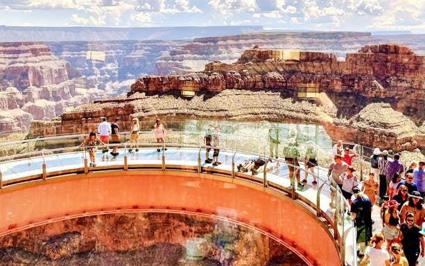 Visitors walking on the Grand Canyon Skywalk with canyon views in Arizona.