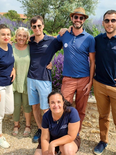 Group of people smiling in a lavender field during a half-day tour.