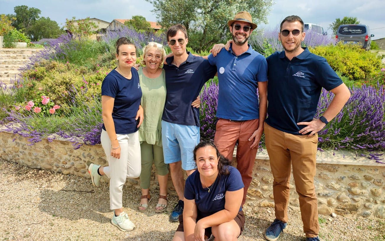 Group of people smiling in a lavender field during a half-day tour.
