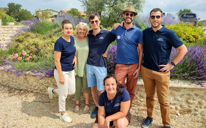 Group of people smiling in a lavender field during a half-day tour.