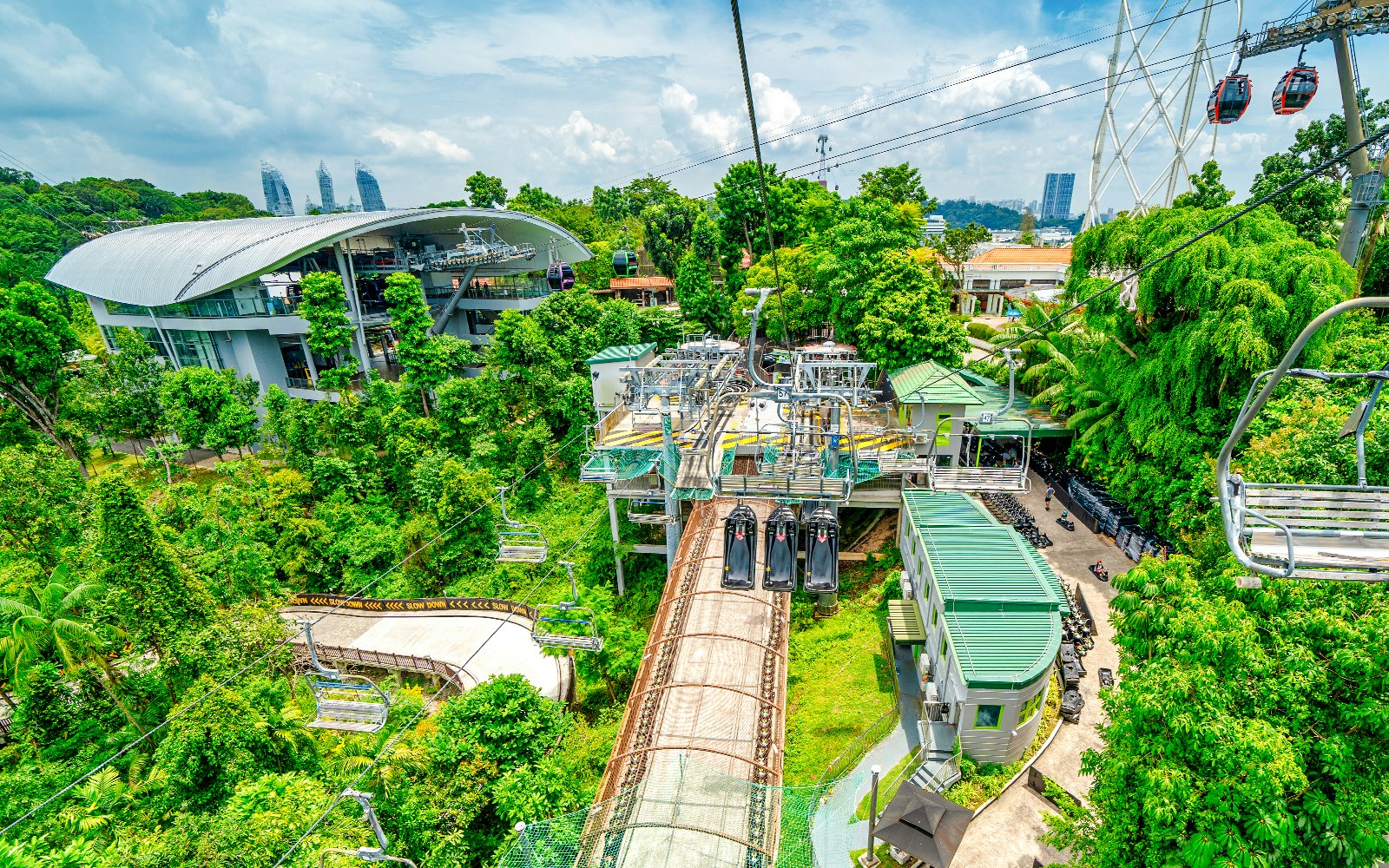 Aerial view of Sentosa cable car station and Luge track surrounded by lush greenery.