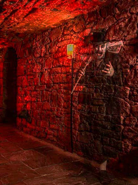 Underground stone corridor with ghostly figure on a famous ghost tour.