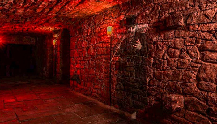 Underground stone corridor with ghostly figure on a famous ghost tour.