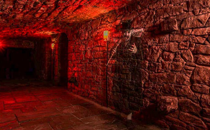 Underground stone corridor with ghostly figure on a famous ghost tour.