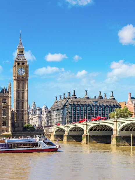 River cruise boat on the Thames near Big Ben and Westminster Bridge, London.