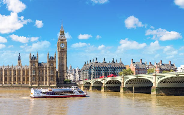 River cruise boat on the Thames near Big Ben and Westminster Bridge, London.