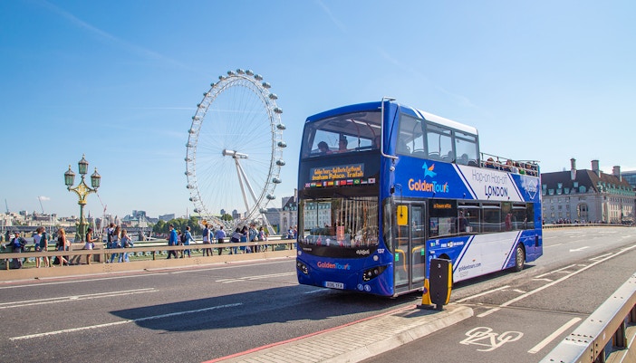 Hop on Hop off London bus near the London Eye on a sunny day.