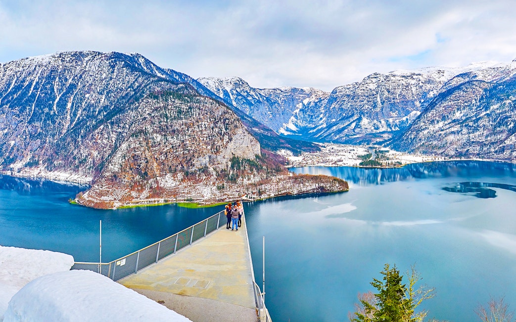 Skywalk viewpoint overlooking Hallstatt lake and snow-capped mountains.