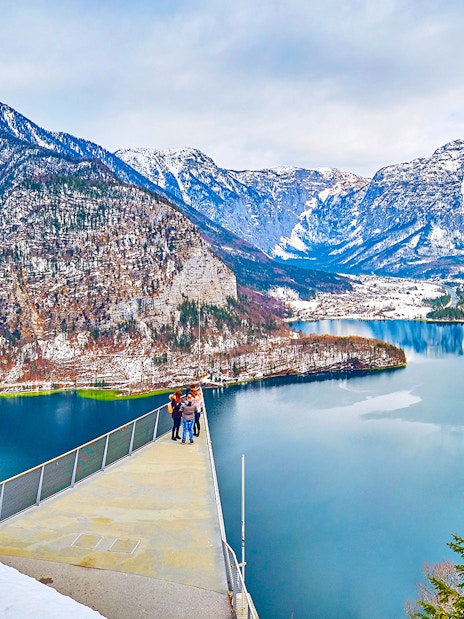 Skywalk viewpoint overlooking Hallstatt lake and snow-capped mountains.