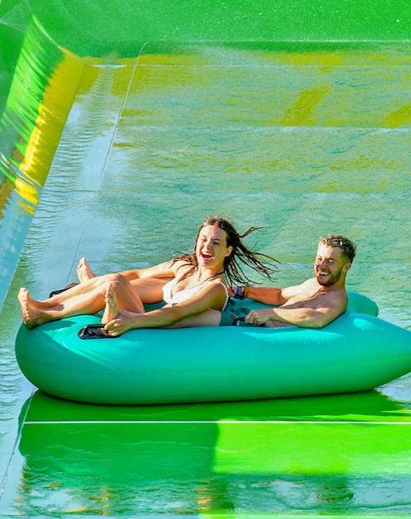 Visitors enjoying a water slide at WaterBom Bali theme park.