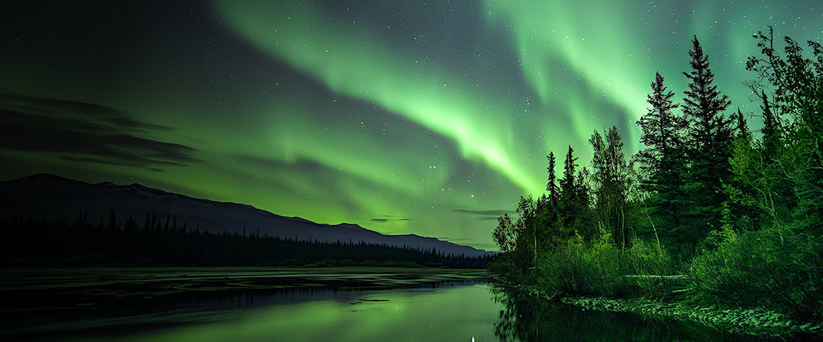 Northern Lights over a forested riverbank in Rovaniemi, Finland.