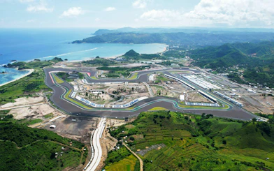 Aerial view of Mandalika Circuit in Lombok, Indonesia, with surrounding landscape and coastline.