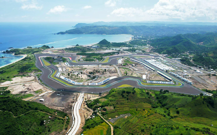 Aerial view of Mandalika Circuit in Lombok, Indonesia, with surrounding landscape and coastline.