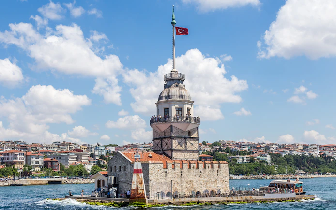 Maiden's Tower on Bosphorus Strait with Istanbul cityscape in the background.