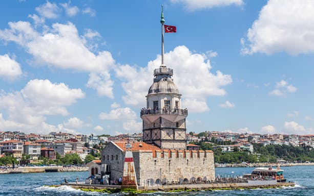 Maiden's Tower on Bosphorus Strait with Istanbul cityscape in the background.