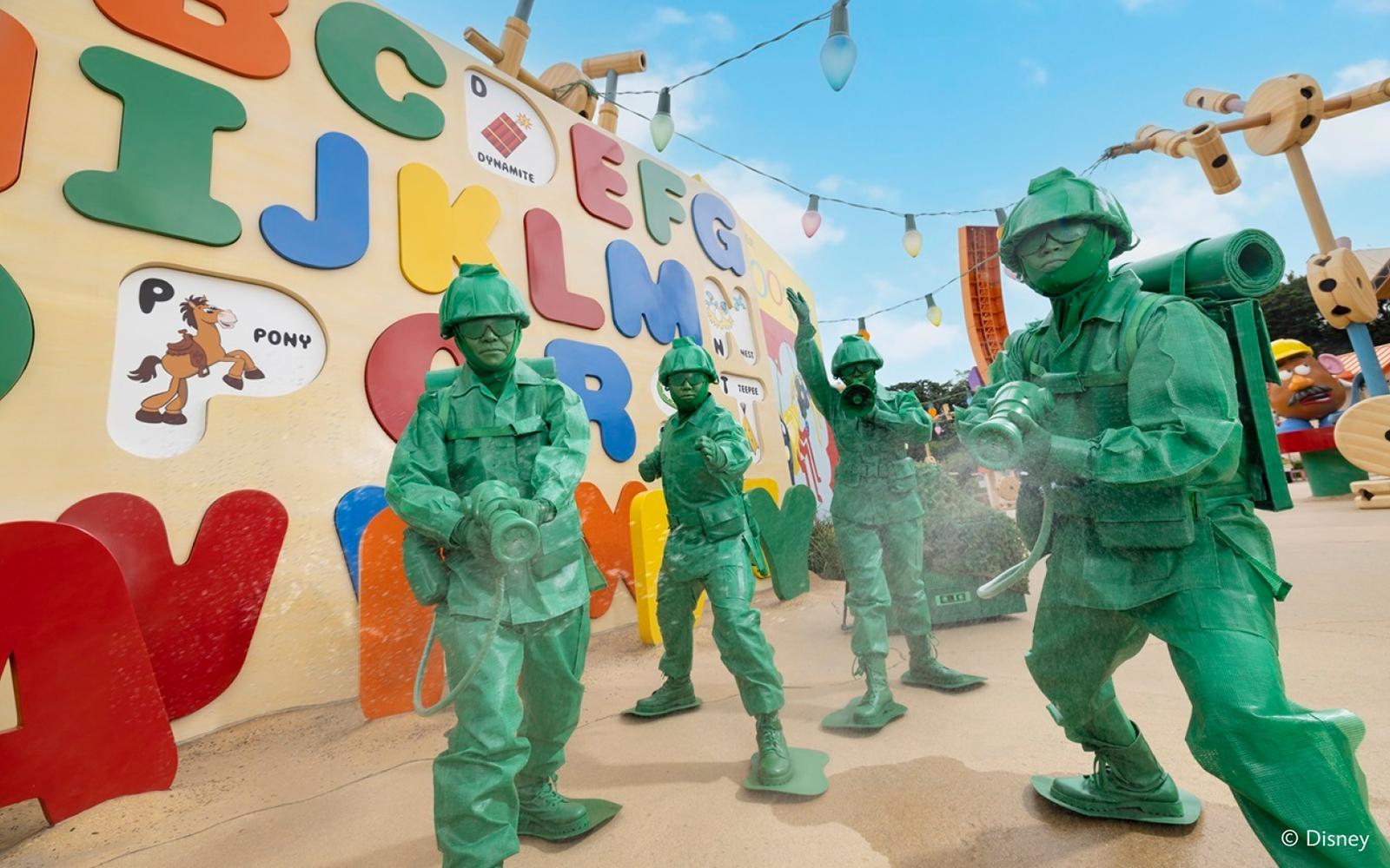 Toy soldiers from Toy Story at Disneyland Hong Kong in front of colorful alphabet wall.