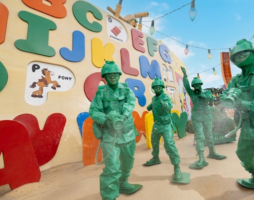 Toy soldiers from Toy Story at Disneyland Hong Kong in front of colorful alphabet wall.