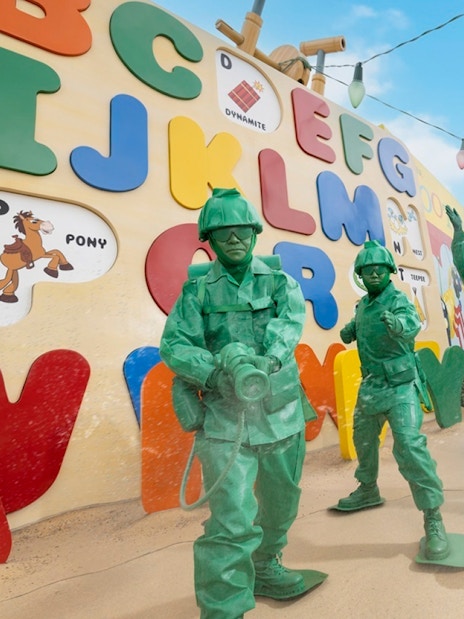Toy soldiers from Toy Story at Disneyland Hong Kong in front of colorful alphabet wall.