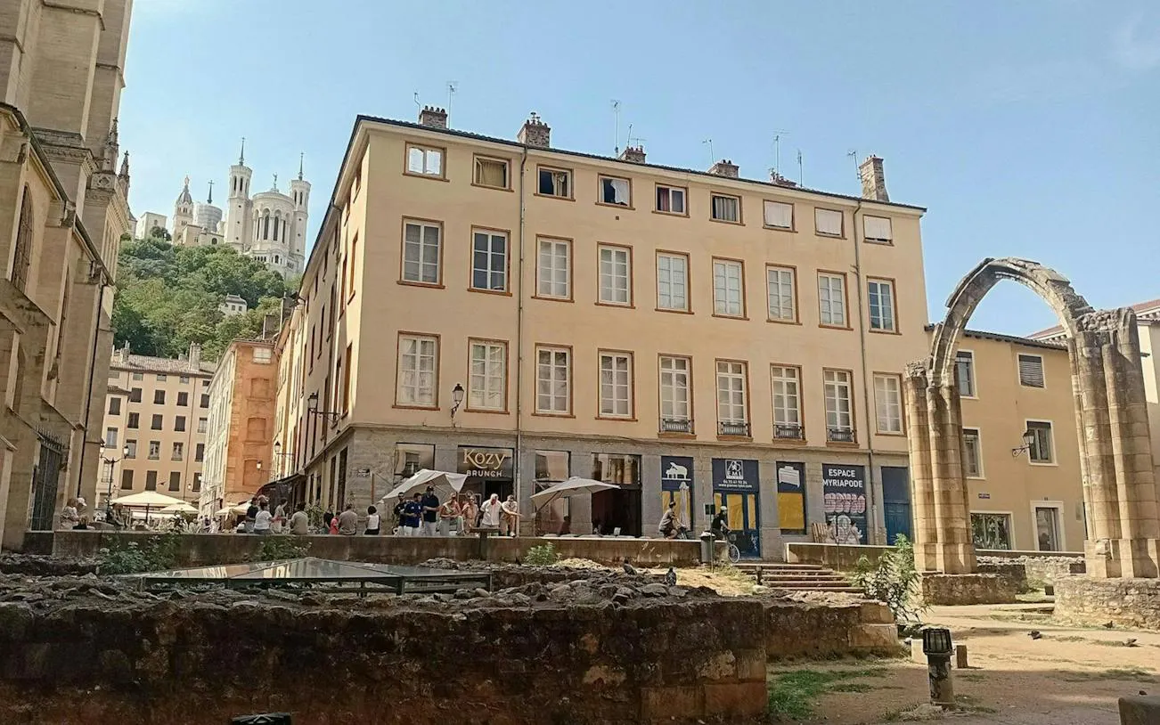 Lyon street with Roman ruins and Basilica of Notre-Dame de Fourvière in the background.
