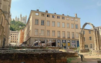 Lyon street with Roman ruins and Basilica of Notre-Dame de Fourvière in the background.