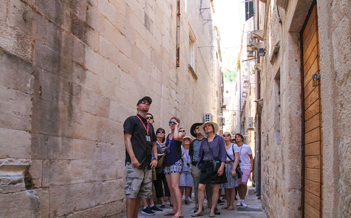 Group exploring narrow street in Dubrovnik's Old Town during walking tour.