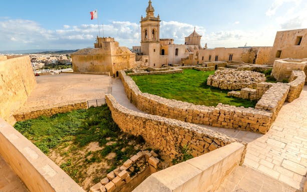 View from the ramparts of the Cittadella in Victoria, Gozo, showing historic stone walls and buildings.