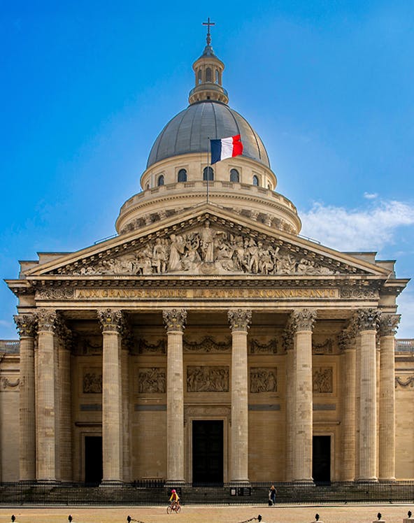 Pantheon in Paris with French flag atop the dome, showcasing neoclassical architecture.