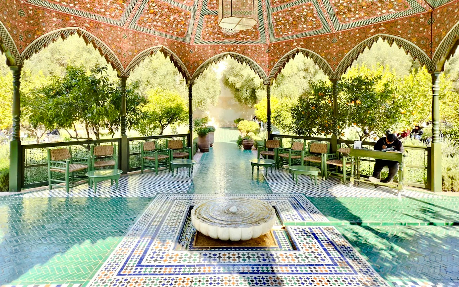 Le Jardin Secret pavilion with intricate tilework and lush greenery in Marrakech, Morocco.